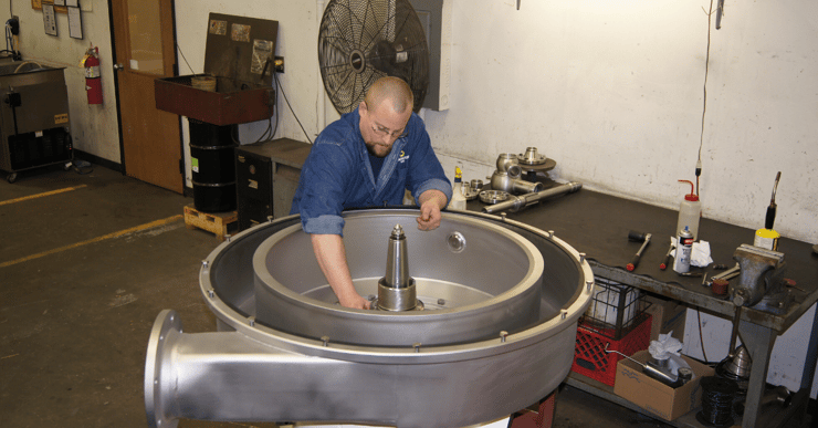 Image of a man reassembling a centrifuge during centrifuge maintenance