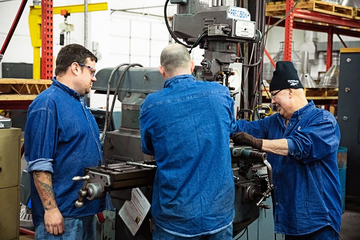 three separators employees working on a centrifuge